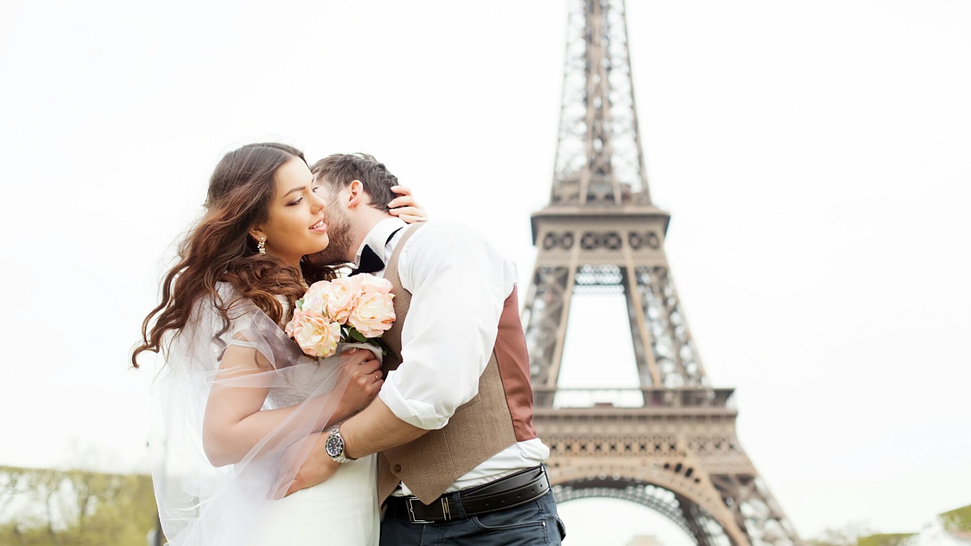 Just married couple near the Eiffel tower on their wedding day. Bride and groom in Paris, France